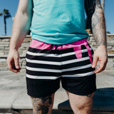 Model wearing Kinda Fit Kinda Fit Black Training Shorts. KFKF Pink Icing Drip along the waistband. OG Donut Logo tag over the right leg 