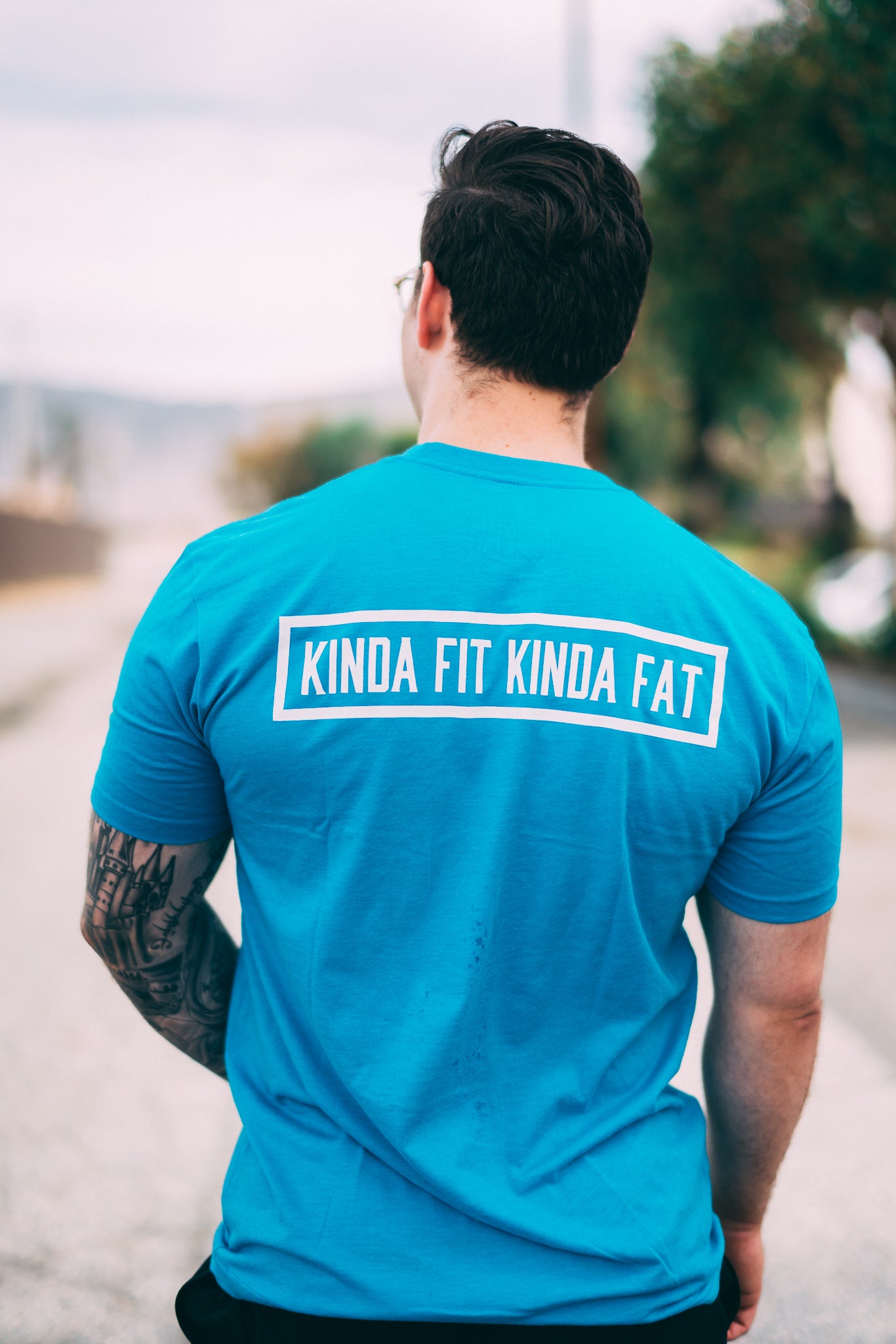 Kinda Fit Kinda Fat Premium Unisex Turquoise T-shirt. Original KFKF Cookie Logo on front left chest. Kinda Fit Kinda Fat Bar Logo Back. 