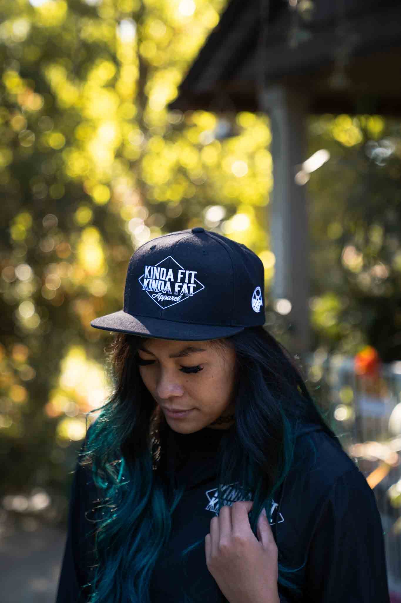 Model wearing Kinda Fit Kinda Fat Diamond Drip Logo Unisex Black Snapback Hat. Front shot.